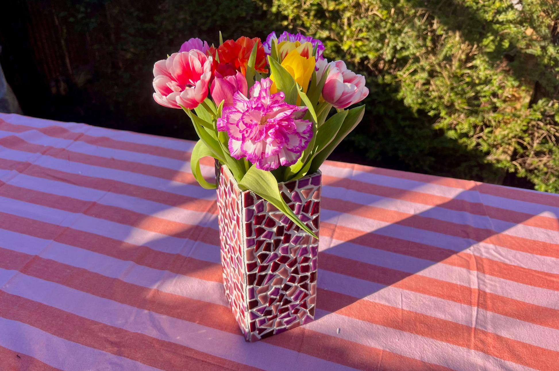 Mozaïek vaas met bloemen in de zon